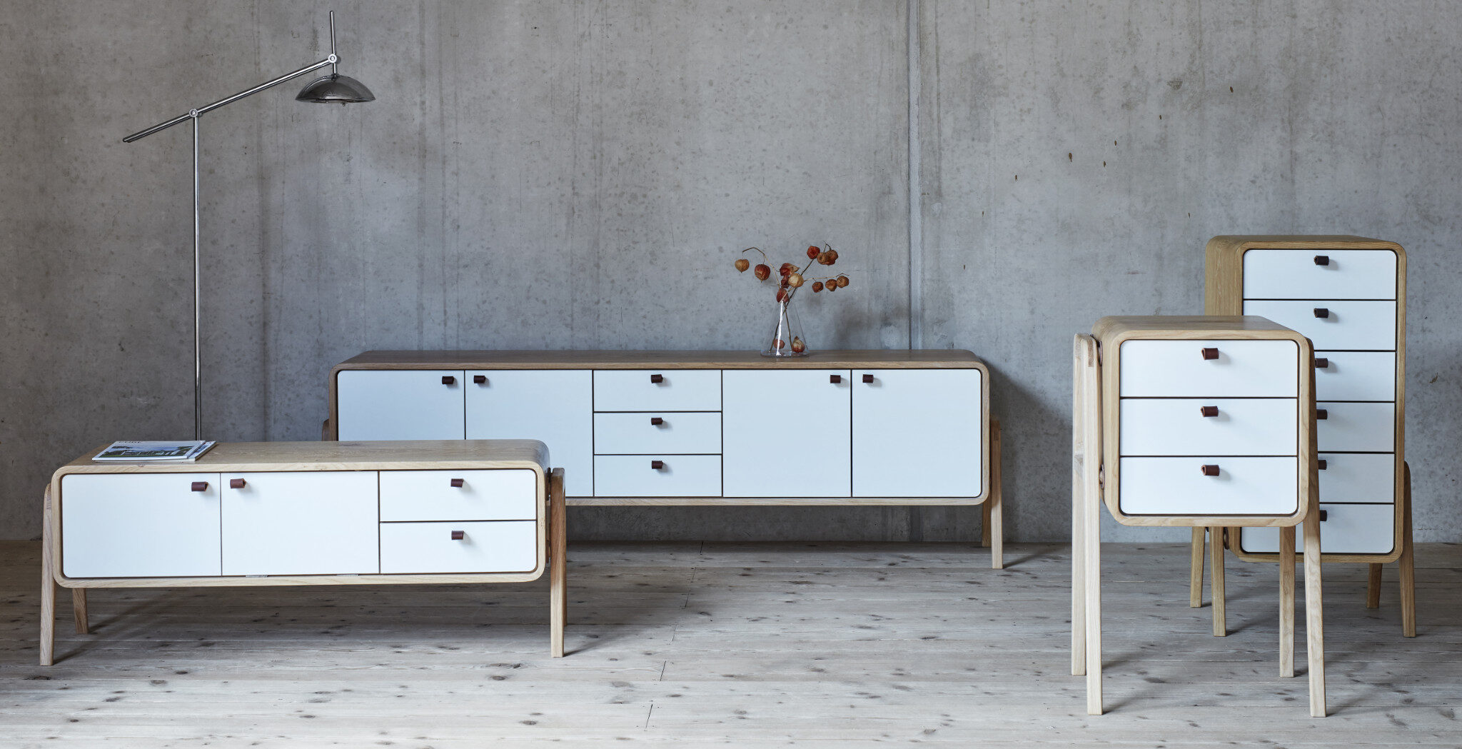 Premium sideboards and cabinets with white fronts against a concrete wall. nordlys møbler: HANDMADE - SCANDINAVIAN - FURNITURE from Norwegian oak.