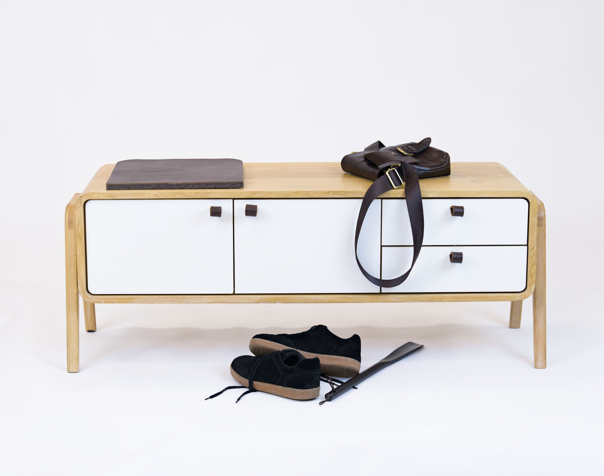 Low nm23L sideboard styled as an entryway bench with leather cushion, bag and shoes. nordlys møbler: HANDMADE - SCANDINAVIAN - FURNITURE from Norwegian oak.