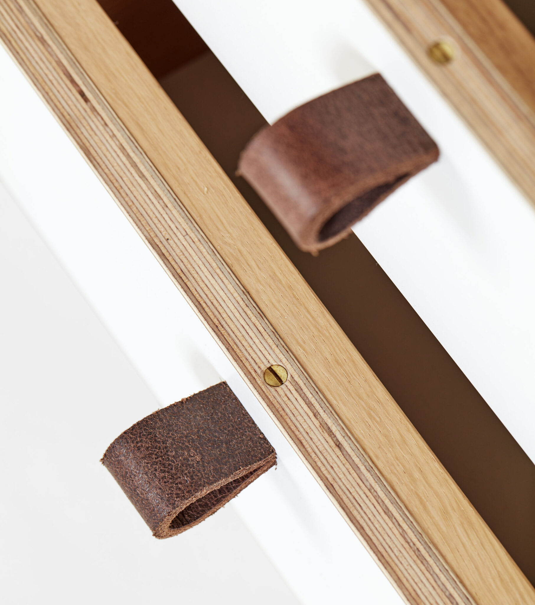 Detail of open white drawers featuring fine woodwork and handmade 4mm buffalo leather pulls. nordlys møbler: HANDMADE - SCANDINAVIAN - FURNITURE from Norwegian oak.